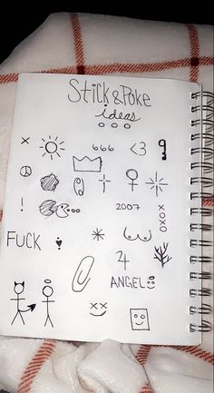 a notebook with stick and poke on it sitting on top of a pile of blankets