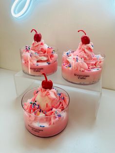 three desserts with ice cream and sprinkles in glass dishes on a counter