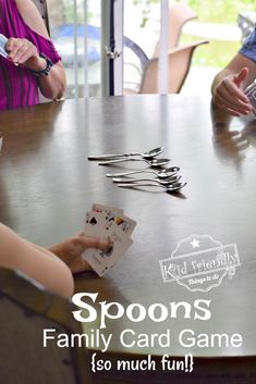 spoons and family card game sitting on a table in front of two adults playing cards