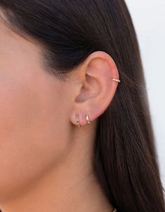 a woman wearing an ear cuff with two small gold bars on the back of her ear