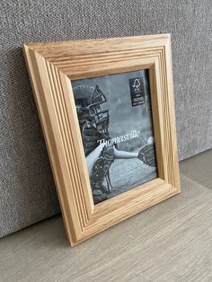 a wooden frame with a baseball glove on the floor in front of a gray couch