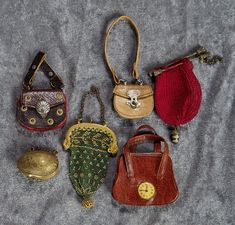 four purses and two coin purses on a gray cloth with a silver chain