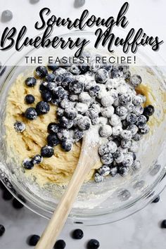 blueberry muffins in a glass bowl with a wooden spoon