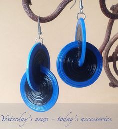 two blue circular earrings hanging from a tree branch with the words saturday's news today accessories written below them