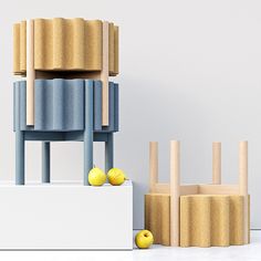 an artistic display with yellow apples in front of two wooden chairs and one chair made out of plywood sticks