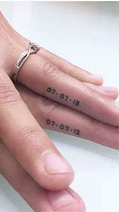 two people with tattoos on their fingers and one is holding the other's hand