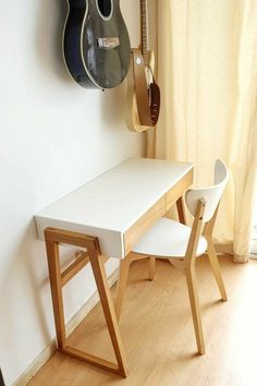 a white table with two guitars hanging on the wall