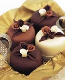 some brown and white cakes are in a basket with ribbons on it's sides