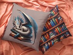 two pillows on a bed with books and a dragon