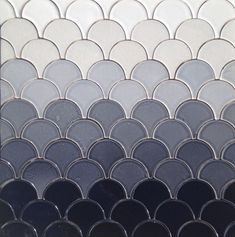 a close up view of a black and white mosaic tile wall with circles on it