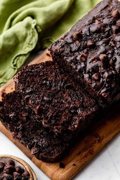 a loaf of chocolate cake sitting on top of a wooden cutting board