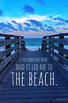 a wooden walkway leading to the beach with an ocean in the background that says, i followed my heart and it led me to the beach