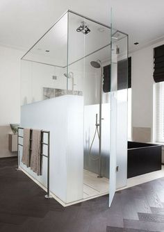 a glass walled shower in a white bathroom