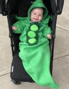 a baby in a pea costume sitting in a stroller