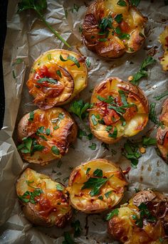 baked potatoes with tomatoes and herbs on parchment paper, ready to be served in the oven