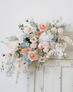 a bunch of flowers that are on top of a white door handle and in front of a wall