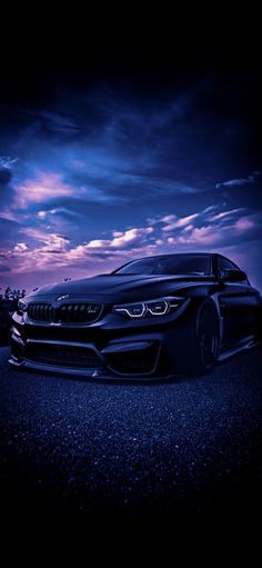 a car parked on the side of a road under a purple sky with clouds in the background