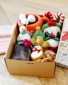 an open box filled with different types of christmas decorations on top of a wooden table