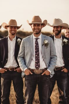 a group of men standing next to each other wearing cowboy hats