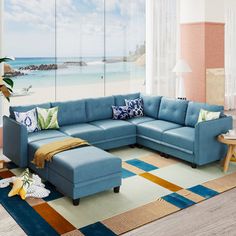 a living room with a blue sectional couch and colorful rug on the floor next to it