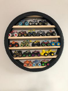 a wall mounted toy rack with cars and trucks on it's sides in a circle