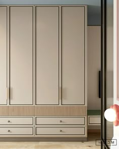 an empty room with white cupboards and beige drawers on the wall, in front of a blue ceiling