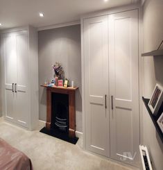 a bedroom with white closets and an entertainment center in the corner between two walls