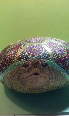 a turtle is sitting on top of a decorative pillow that looks like it has been made out of fabric