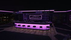 a dimly lit bar with stools in front of it at night, overlooking the city