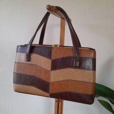 Vintage 1970s vinyl patchwork handbag, a true fashion statement that effortlessly combines nostalgia and timeless style. The photos are part of the description so please check them out.  Colours may vary in photos and video due to light levels and different monitors. *  Vintage 1970s vinyl/faux leather bag with patchwork effect detail to front in shades of brown. *  Two open side compartments and one inner closed compartment.  *  Fully lined with brown acetate fabric and with open inner side mir Vintage 1970 Handbags, Retro Vintage Brown Rectangular Shoulder Bag, Retro Brown Satchel Shoulder Bag, Vintage Brown Square Bag, Vintage Brown Rectangular Shoulder Bag, Vintage Brown Retro Satchel Bag, Retro Brown Tote Shoulder Bag, Vintage Brown Rectangular Bag, Retro Brown Tote Satchel