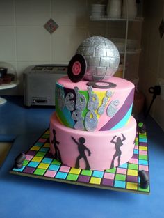 there is a cake that has disco themed decorations on the top and bottom tiers