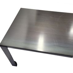 a metal table that is sitting on a white surface with no one around it,