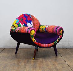 a colorful chair sitting on top of a hard wood floor