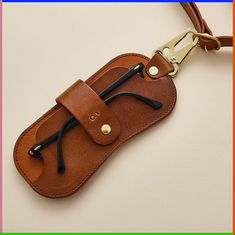 a brown leather case with two black handles on a white background and an orange frame around it