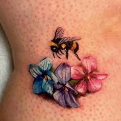 a woman's stomach with flowers and a bee on it