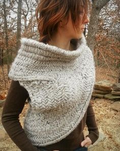 a woman wearing a knitted cowl in the woods with her hands on her hips