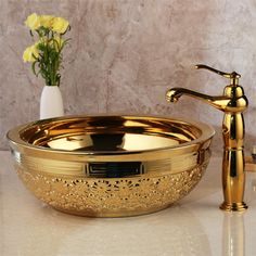 a gold sink with a faucet next to it on a marble countertop