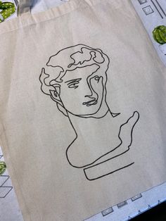 a tote bag with a drawing of a man's face on it