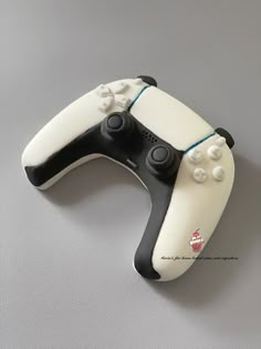 a white and black wii controller on a gray surface