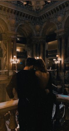 two people embracing each other in front of a chandelier