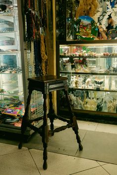 a small wooden stool sitting in front of a store