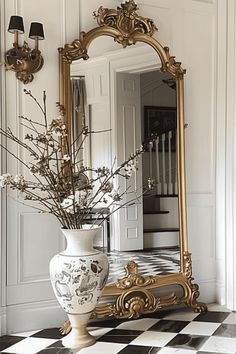 a vase with flowers in it sitting on a checkered floor next to a mirror