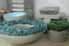 three cement planters sitting next to each other on top of a table with plants in them