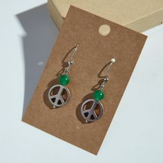 Handmade peace sign drop earrings with translucent green bead detail! These lightweight earrings are a perfect gift or addition to your jewelry collection. Made with silver-colored peace signs, green-colored beads, and Nickel-free earring hooks. Enjoy! Peace Signs, Nickel Free Earrings, Lightweight Earrings, Earring Hooks, Light Weight Earrings, Green Bead, Peace Sign, Hippie Boho, Jewelry Earrings Dangle