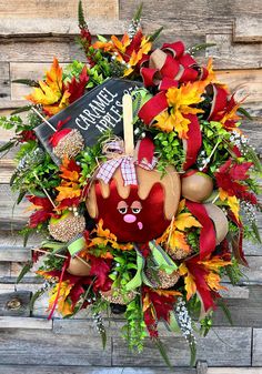 the wreath is decorated with fall leaves, pumpkins and other holiday decorating items