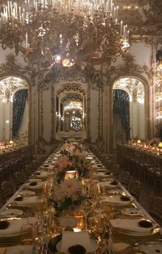 a long table is set with gold plates and place settings for an elegant dinner party