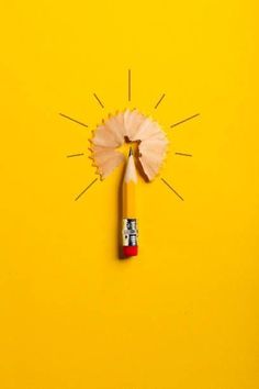 a pencil and paper on a yellow background with an eraser in the shape of a sunburst