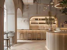 the interior of a restaurant with white walls and wood flooring is lit by lights