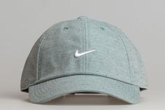 a baseball cap with a white nike logo on the front, and a light blue background