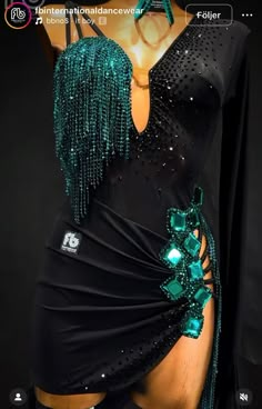 a woman in a black dress with green beading on it's chest and arms